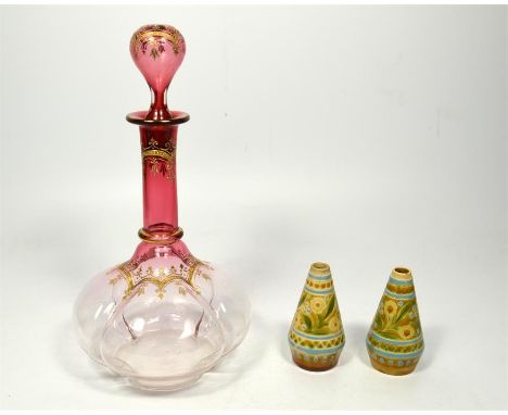 A cranberry flashed decanter with gilt highlights and a pair of small Linthorpe vases, 20th century. Height 25cm and 8cm. (3)