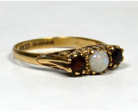 An opal and garnet three stone ring, round Opal, apprx. 4.5mm round with two round apprx. 3mm garnets set to each side, claw 