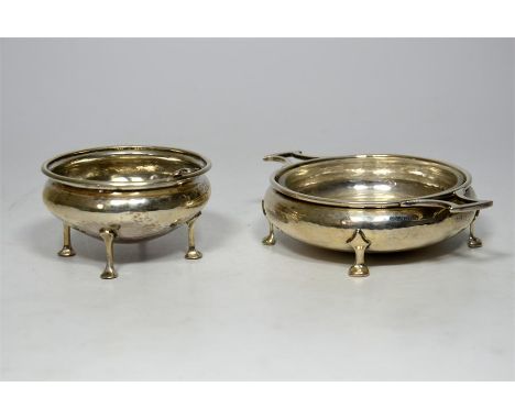 Two silver bowls and a teaspoon, with the bowls raised on four legs. Bowls by Albert Edward Jones, Birmingham 1918 and 1934, 