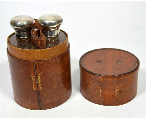 A silver topped pair of glass flasks in a leather case, case stamped H. S., by Percy Whitehouse. London 1901. Height 14.5cm. 