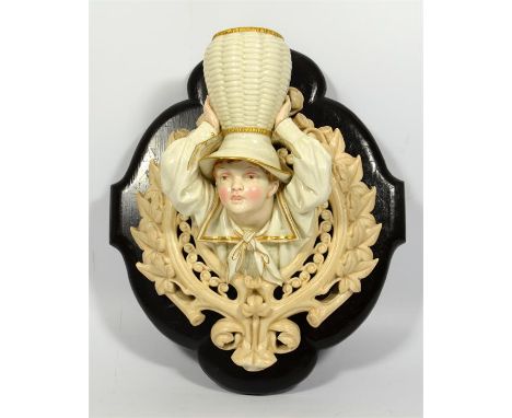 A Royal Worcester wall pocket modelled as a young boy holding a vase above his head, date code for 1885. Height 26cm.