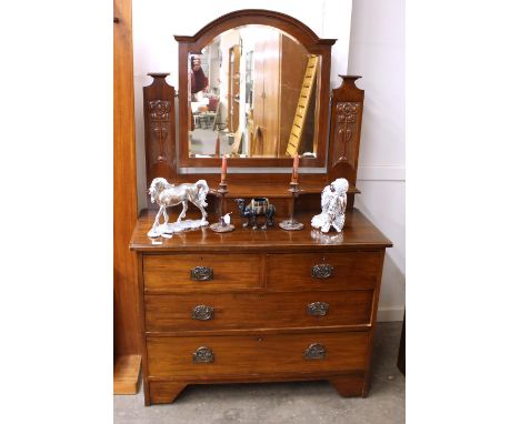 An Edwardian walnut Art Nouveau design three section wardrobe, enclosed by mirrored panel doors fitted two drawers below, rai