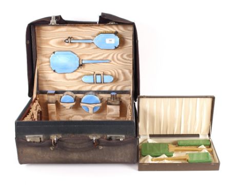 An Art Deco travelling toilet case, having enamel decorated bottles and brush set; and another cased Bakelite brush set