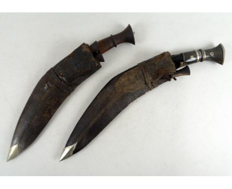 Two early 20th century Kukris, comprising one with white metal ring bound buffalo horn grip, with white metal butt cap and ma