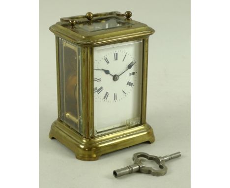 A French brass carriage clock, 19th century, with four bevelled glass panes, the white enamel face with black Roman numerals,