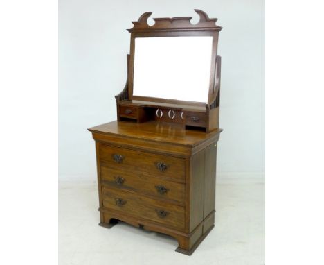 An Art Nouveau oak dressing chest, with rectangular mirror plate, two trinket drawers, over three drawers with metal plate ha