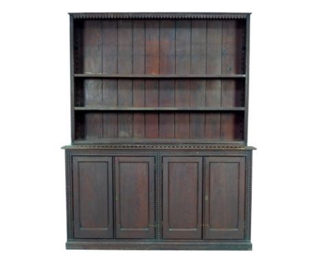 An early 20th century stained pitch pine dresser, with two shelf adjustable rack, two twin door cupboard below with geometric