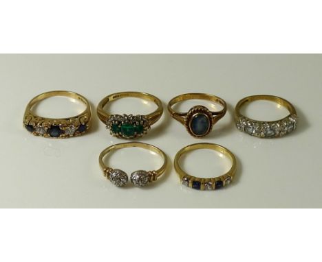 A group of six 9ct gold rings, comprising a ring set with three emeralds surrounded by diamonds, reeded shoulders, band hallm