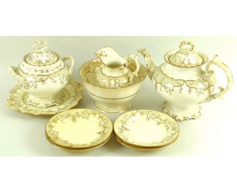 An English porcelain part tea service, early 19th century, the bodies gilt decorated against a cream ground with trailing vin