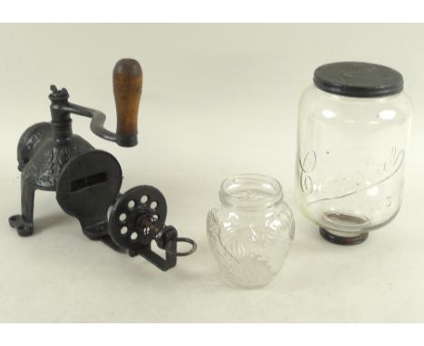 An early 20th century cast iron wall mounted coffee grinder, with wooden handle, in two separate pieces, altogether 22 by 14 