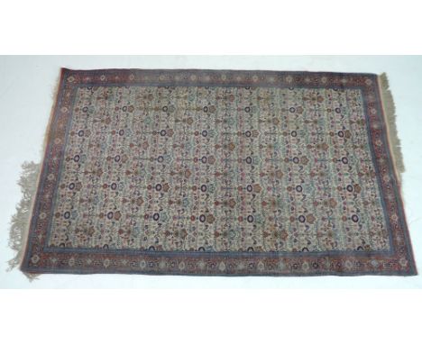 A finely knotted Persian rug, early 20th century, with cream ground and floral all over field, red border with further floral