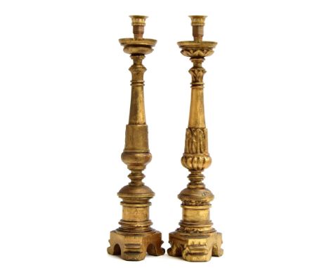 A pair of giltwood altar candlesticks, probably Italian, on cylindrical stems, each decorated with bands of acanthus leaves, 