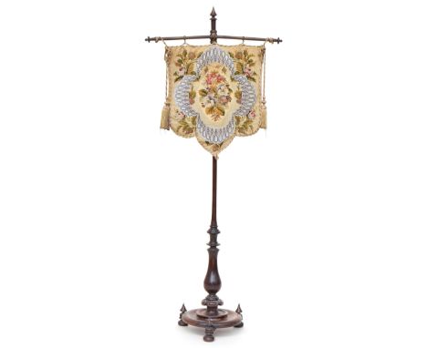 A Victorian rosewood pole firescreen, the embroidered screen supported from brass rail with adjustable height collar on turne