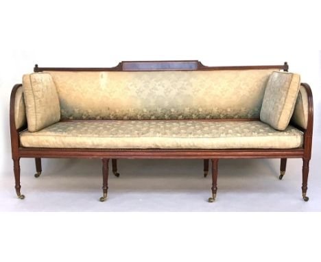 A Regency three seater bergere sofa, with caned seat and upholstered back and sides below a strung and inlayed central collar