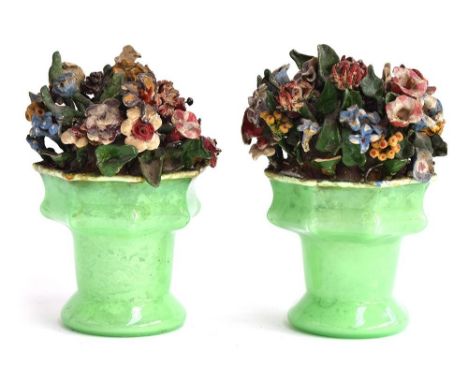 A pair of late 19th century ceramic flower arrangements in green glass vases, 20cmHProvenance: from the estate of Elizabeth P