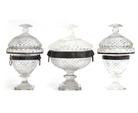 A set of three silvered metal mounted cut glass sweetmeat dishes, each with domed cover, cushion finials, lion mask handles, 
