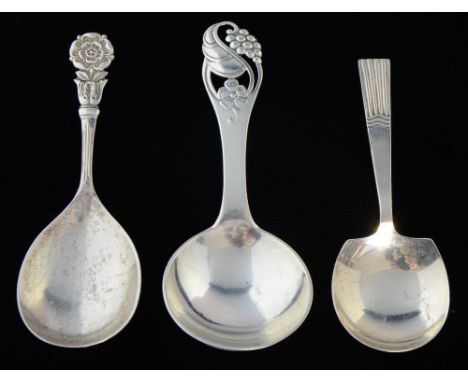 Two English silver and one Danish silver caddy spoons of varied designs