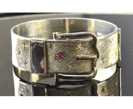 A silver buckle bangle with engraved stars and inset with synthetic ruby another bangle and items of silver