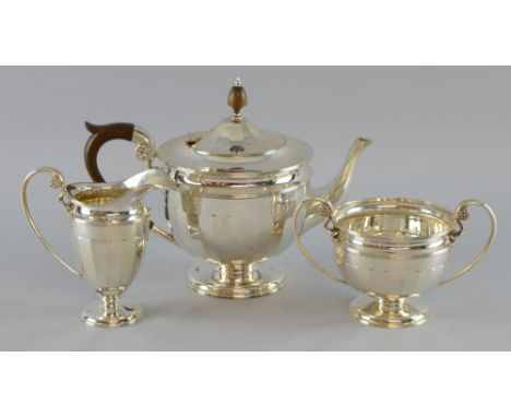 George V silver three piece tea service, comprising teapot, cream jug and sugar bowl, with facetted bodies on round feet, Jam