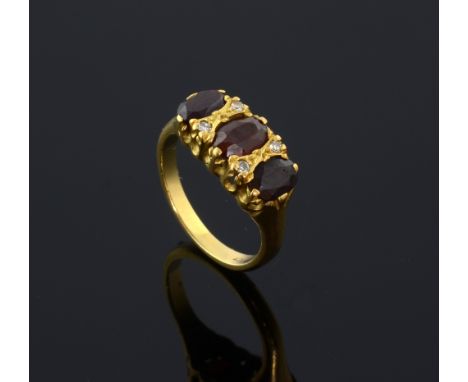 Three stone garnet and diamond dress ring in 18ct yellow gold.