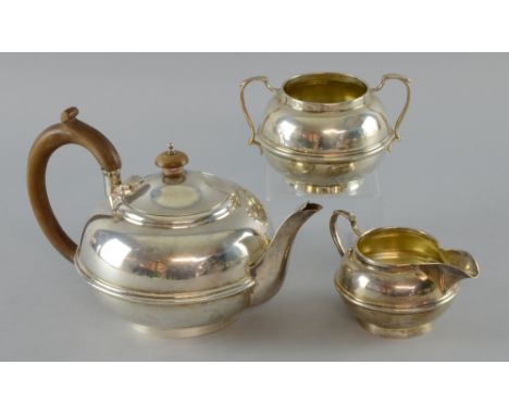 George V silver three piece tea service comprising teapot, sugar bowl and cream jug with a single plain band of decoration an