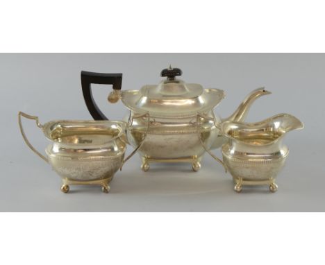 George V silver three piece tea service, comprising teapot, cream jug and sugar bowl, with gadrooned and scroll decorated rim