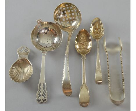 George III silver sifter spoon with bright cut decoration, London, 1777, caddy spoon, tea strainer, sugar tongs and two teasp