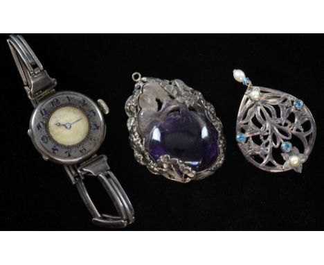 Pendant of carved amethyst set in Chinese silver floral setting, a silver watch with enamel faced dial and a scarf brooch