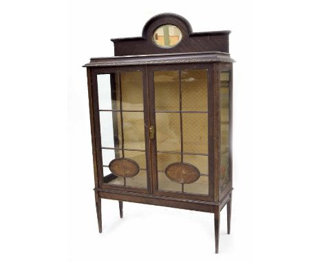 Edwardian mahogany glazed display cabinet, with raised back inset with mirror, over two panelled glazed doors enclosing glass