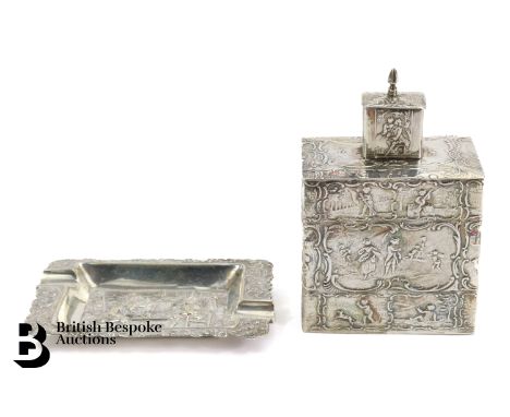 Silver tea caddy chased with continuous scenes of cherubs at play approx 13 h x 8 cms together with a silver ashtray embossed