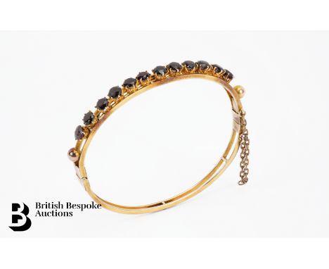 14/15 ct yellow gold Indian garnet bangle, the bangle set with twelve 12 x 5mm garnets, approx 52mm x 60 internal diameter, 1