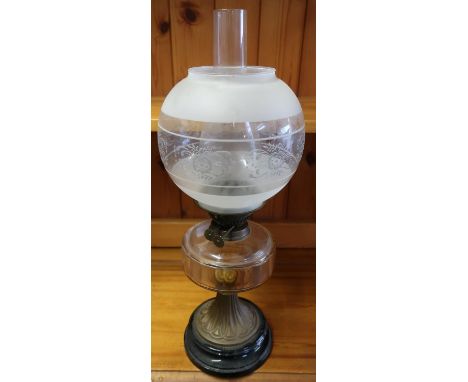 Late 19th C oil lamp with clear glass reservoir, circular tapering embossed brass base on black glazed porcelain base with fr