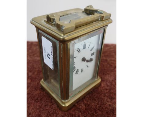 Brass cased French made carriage clock with white enamel dial, complete with key and swing handle (height 12cm) 