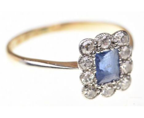 A sapphire and diamond cluster ringThe rectangular step-cut sapphire, to an old-cut diamond square rectangular surround, with
