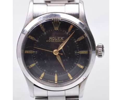 Rolex: An Oyster Perpetual automatic bracelet wrist watchThe signed black dial with gold tone baton hour markers, gold tone h