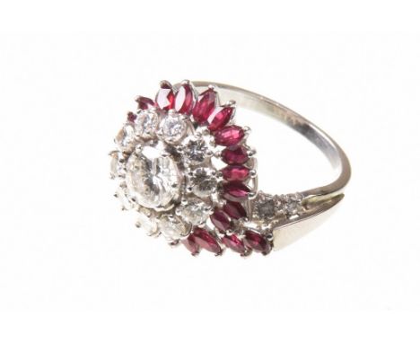 A diamond and ruby cocktail ringCentering a round brilliant-cut diamond, to a round brilliant-cut diamond cluster, border by 