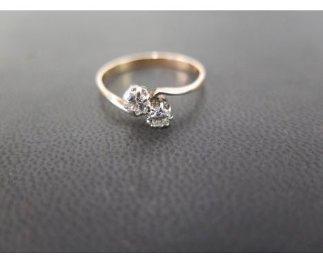 A diamond two-stone crossover ring - The brilliant-cut diamonds to the asymmetric shoulders of plain band - Estimated total d