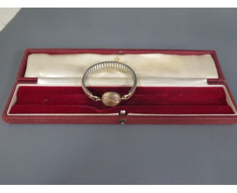 A 9 ct gold Garrard ladies manual wind wristwatch, on a plated sprung strap - Width 2 cm 
Condition report: Working, some usa