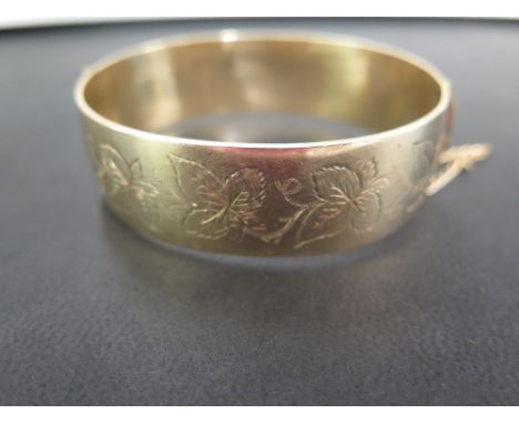 A hinged bangle - With foliate detail - Stamped 9ct metal core - Weight approx 52.2gms
Condition Report: Good to fair - With 
