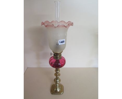 A Cranberry reservoir oil lamp on brass candlesticks base with tinted shade - Height 52 cm 
Condition report: Overall good co