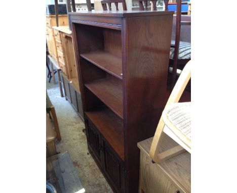 AN ERCOL BOOKCASE WITH LINEN FOLD LOWER CABINET DOORS