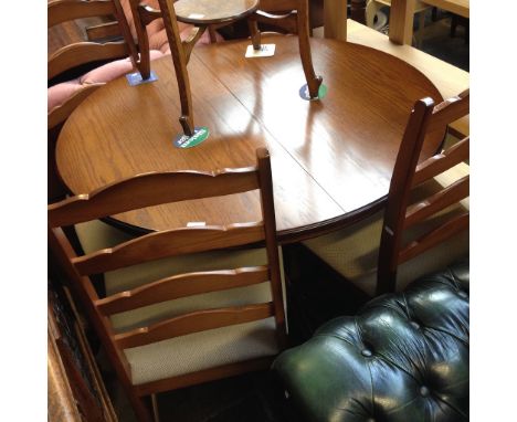 AN OAK ROUND EXTENDING DINING TABLE AND 4 LADDER BACK CHAIRS