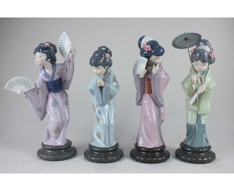 A set of four Lladro porcelain figures of geishas, one with a parasol and a fan, two with fans, and one bowing, tallest 32cm 