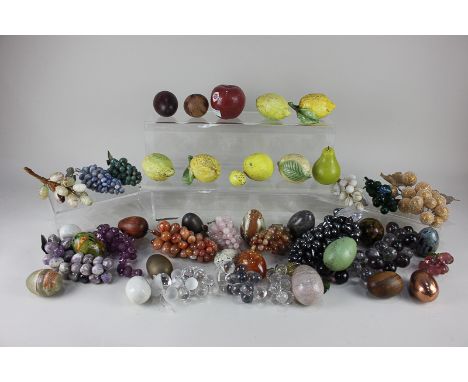 A collection of ornamental fruit including bunches of grapes in coloured stones, ceramic lemons and various egg shaped orname
