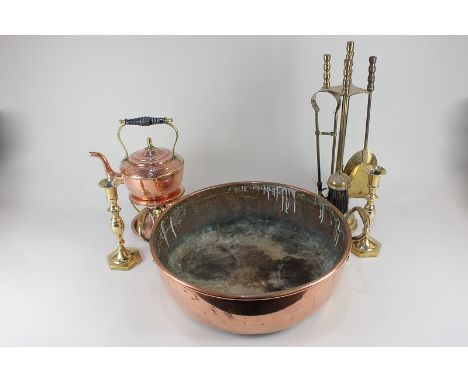 A copper preserve pan, a set of brass fire tools, a copper kettle with warmer on stand, and a pair of brass candlesticks