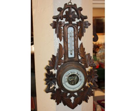 A wall barometer / thermometer, within a pierced floral and foliate carved frame, 46cm