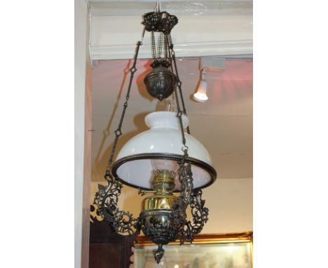 An ornate scrolling foliate hanging oil lamp, the brass lamp marked Albion, with white shade and clear glass funnel, 75cm (a/