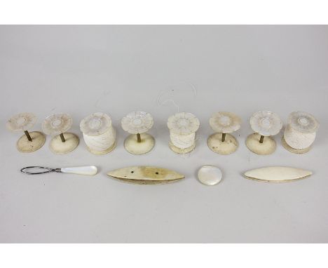 A set of eight early 20th century mother of pearl thread reels with floral design, together with two bone reels, a mother of 
