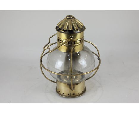 A brass oil lamp with globular glass shade and carrying handle, 28cm