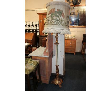 A gilt painted wood standard lamp with green and white fluted stem and leaf carved base, on paw feet, 146cm, with a cream tas